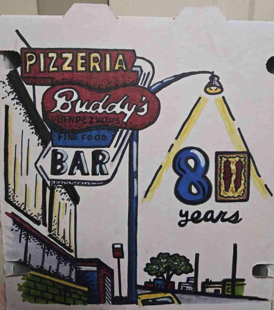 Buddy's Pizzeria sign celebrating 8 years with a colorful mural and outdoor seating area.